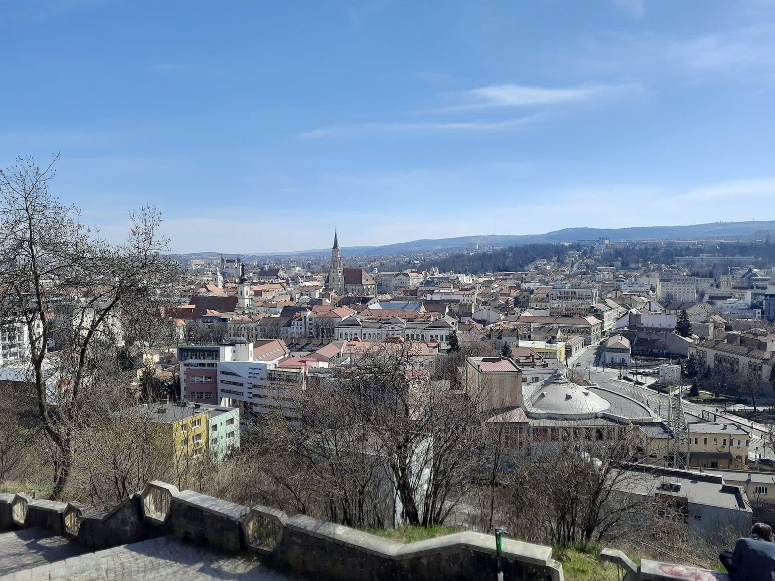 Centrul Clujului văzut de pe Dealul Cetățuia într-o zi senină, cu turla Bisericii Sfântul Mihail și dealurile din sud la orizont